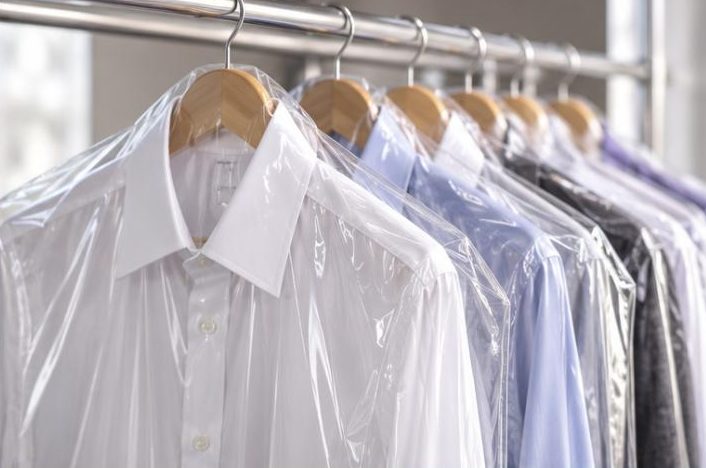 Shirts on hangers in dry cleaning bags