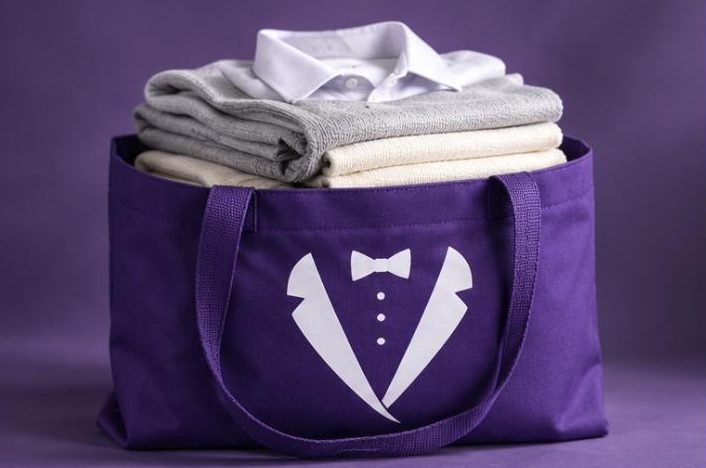 Folded laundry packed in a purple Velvet delivery bag